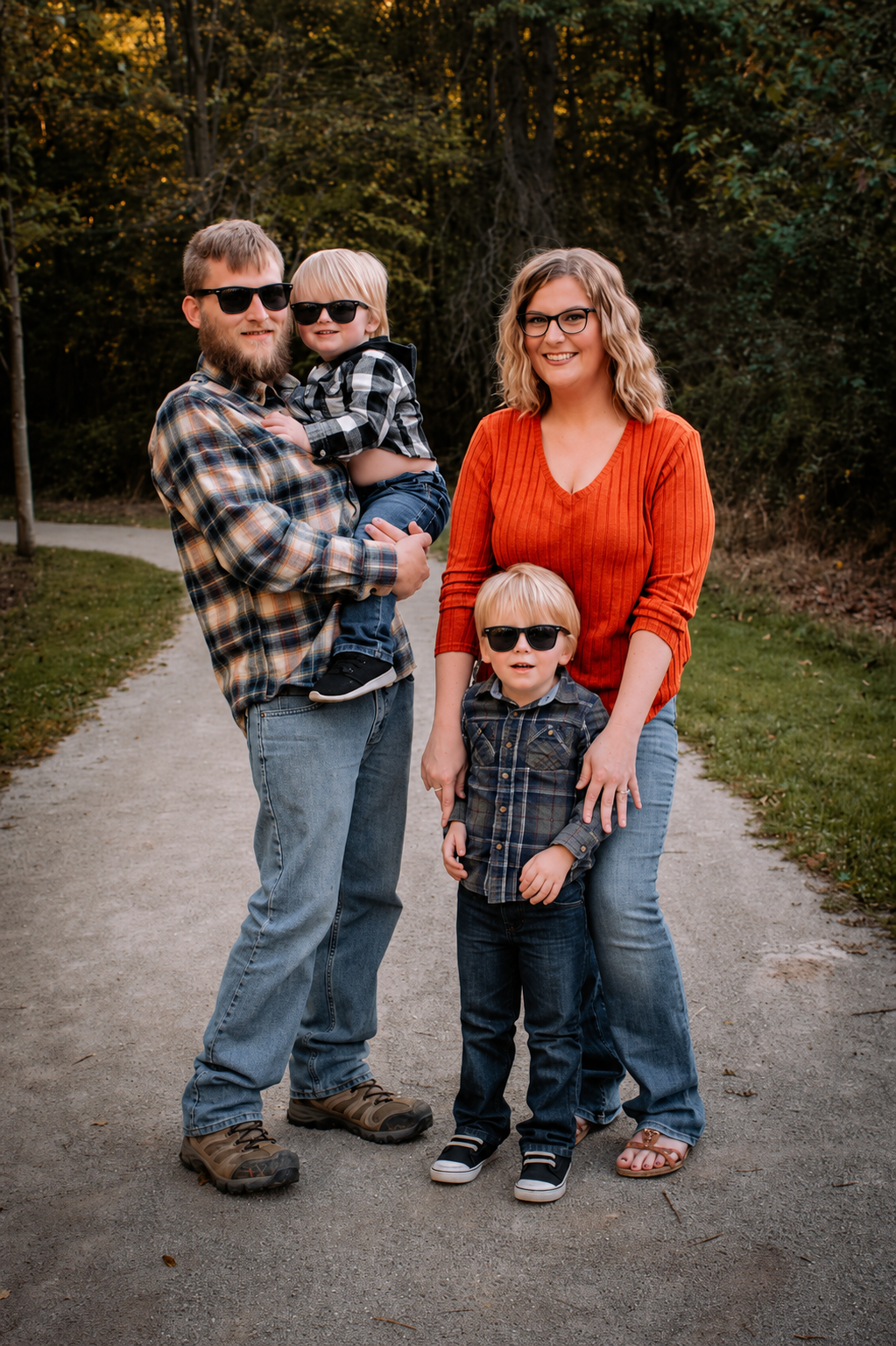 Brittany, her husband, and their two boys outdoors in the fall